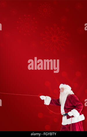 Composite image of santa pulls something with a rope Stock Photo