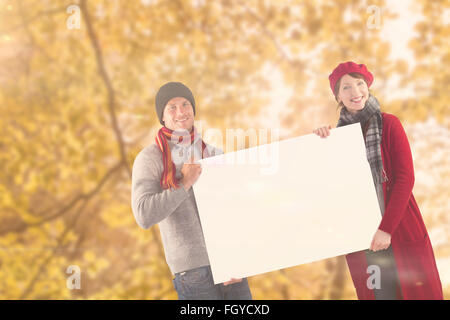 Composite image of couple holding a large sign Stock Photo