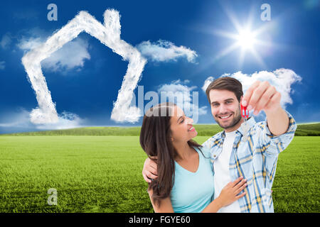Composite image of happy young couple showing new house key Stock Photo