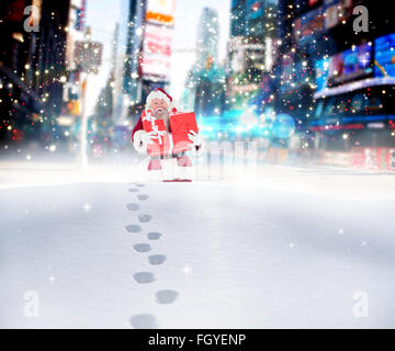Composite image of santa carrying gifts in the snow Stock Photo