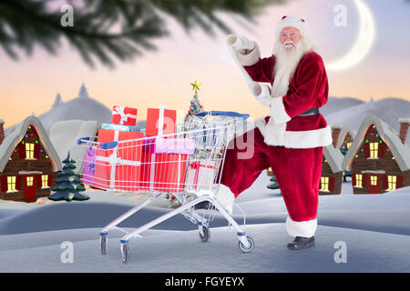 Composite image of santa delivering gifts from cart Stock Photo