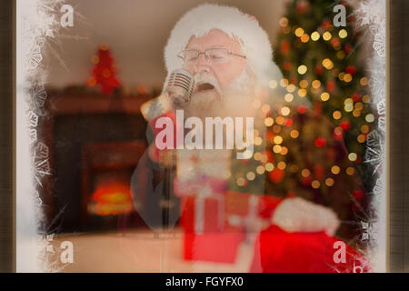 Composite image of santa claus is singing christmas songs Stock Photo