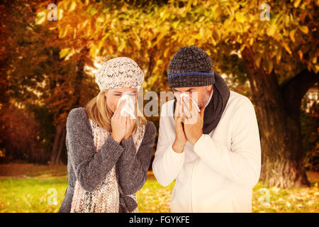 Composite image of couple sneezing in tissue Stock Photo
