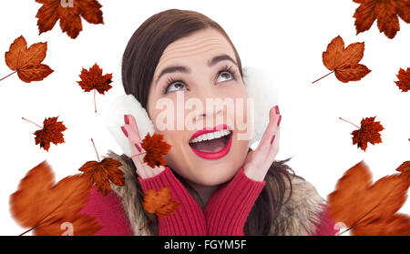 Composite image of surprised brunette in winter clothes Stock Photo