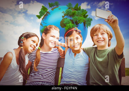 Composite image of happy children taking selfie at park Stock Photo