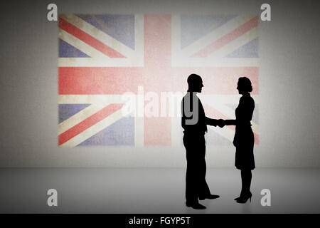 Composite image of silhouettes shaking hands Stock Photo