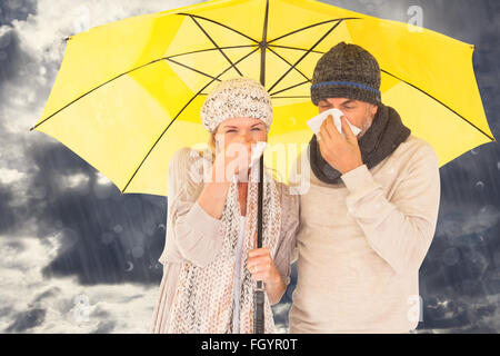 Composite image of couple sneezing in tissue while standing under umbrella