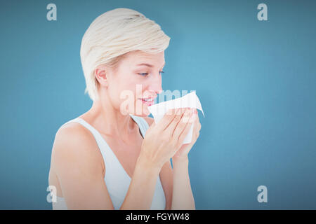 Composite image of sick blonde sneezing Stock Photo