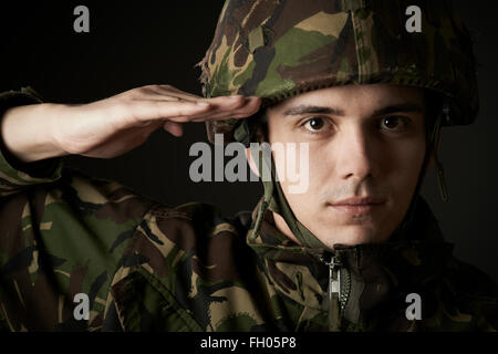 Portrait Of Soldier In Uniform Saluting Stock Photo