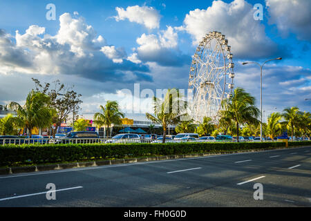 Ferris wheel and Seaside Boulevard, in Pasay, Metro Manila, The Philippines. Stock Photo