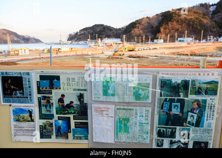 Newspapers show the damages after the 2011 Great East Japan Earthquake and Tsunami have stuck Onagawa city, while construction trucks continue working five years after, on February 11, 2016, Miyagi Prefecture, Japan.  A few weeks before of the fifth anniversary of 2011 Tohoku Earthquake and Tsunami, the Japanese government announced that the second half of the reconstruction work in the Tohoku area is expected to be concluded before the 2020 Tokyo Olympics begin. According to the official Reconstruction Agency's website approximately $250 billion were allocated to the first period (2011-2015)  Stock Photo