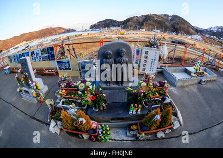 Floral tribute for the victims of the 2011 Great East Japan Earthquake and Tsunami have stuck Onagawa city, while construction trucks continue working five years after, on February 11, 2016, Miyagi Prefecture, Japan.  A few weeks before of the fifth anniversary of 2011 Tohoku Earthquake and Tsunami, the Japanese government announced that the second half of the reconstruction work in the Tohoku area is expected to be concluded before the 2020 Tokyo Olympics begin. According to the official Reconstruction Agency's website approximately $250 billion were allocated to the first period (2011-2015)  Stock Photo