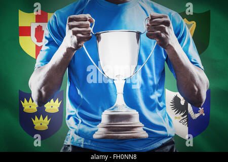 Composite image of mid section of sportsman holding trophy Stock Photo