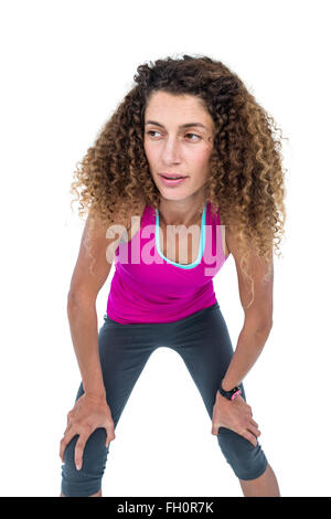 Tired young woman with hand on knees Stock Photo
