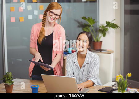 Portrait of businesswomen using technologies in office Stock Photo