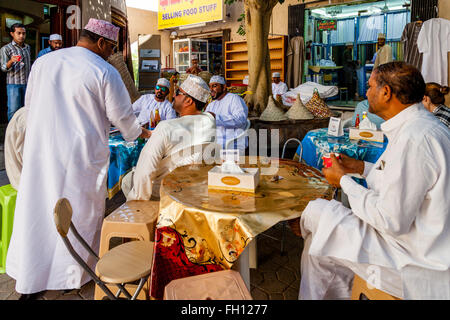 A Group Of Omani Men Sit Chatting At A Cafe In The Souk At Nizwa, Ad Dakhiliyah Region, Oman Stock Photo