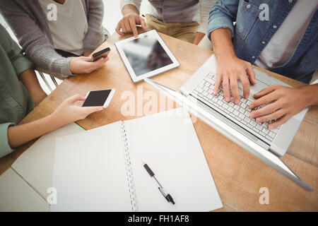 Mid section of business people using laptop and smartphones Stock Photo