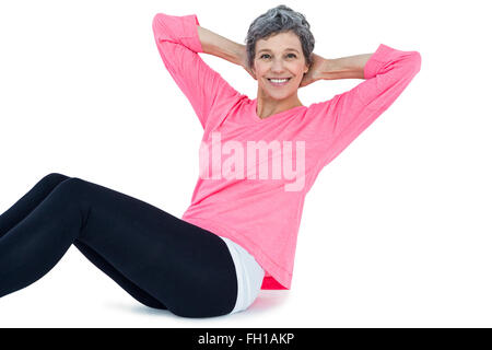 Portrait of mature woman doing sit ups Stock Photo
