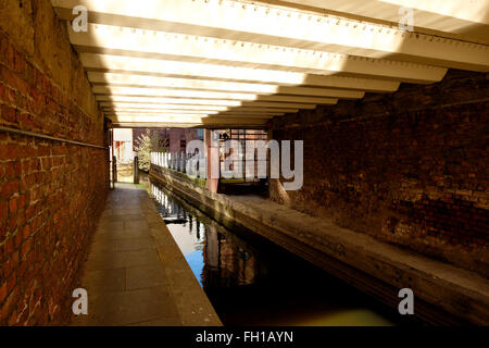 Manchester, UK - 15 February 2016: Small canal tunnel under Great Bridgewater Street leading to Barbirolli Square Canal Basin Manchester, UK - 15 February 2016: Small canal tunnel under Great Bridgewater Street leading to Barbirolli Square Canal Basin