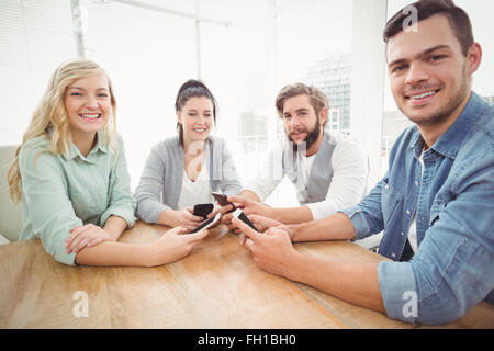 Portrait of smiling business people using smartphones Stock Photo