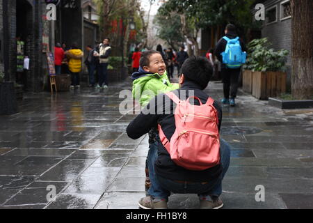 Chengdu, China's Sichuan Province. 23rd Feb, 2016. People go sightseeing in light rain at the Wide and Narrow Alleys in Chengdu, capital of southwest China's Sichuan Province, Feb. 23, 2016. Chengdu received a light rain on Tuesday. Credit:  Guo Qiuda/Xinhua/Alamy Live News Stock Photo