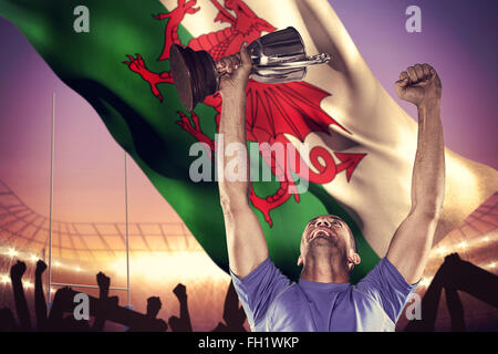Composite image of happy rugby player holding trophy Stock Photo