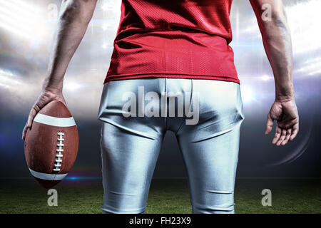 Composite image of mid section of sportsman with american football Stock Photo