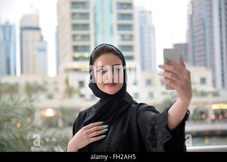 Young beautiful Emirati arab woman taking selfie with her smartphone Stock Photo