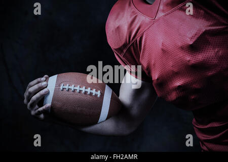 Composite image of cropped american football player holding ball Stock Photo