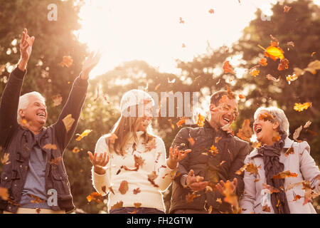 Happy family throwing leaves around Stock Photo