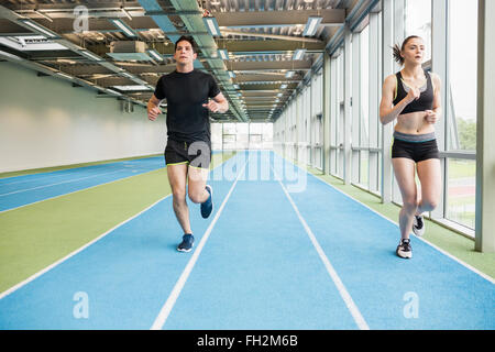 Couple running on the indoor track Stock Photo