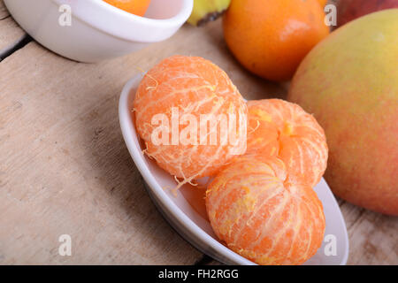 Bowls of slices mandarin with apple on rustic wooden background Stock Photo