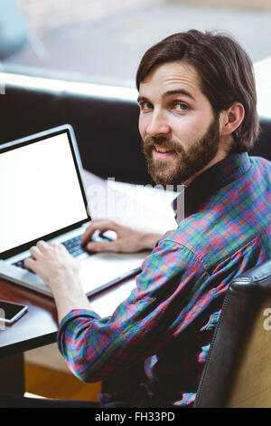Hipster student using laptop in canteen Stock Photo