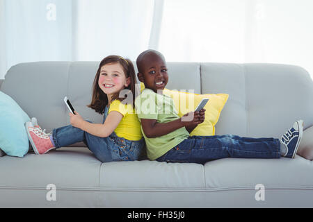 Smiling girl and boy using mobile phones Stock Photo