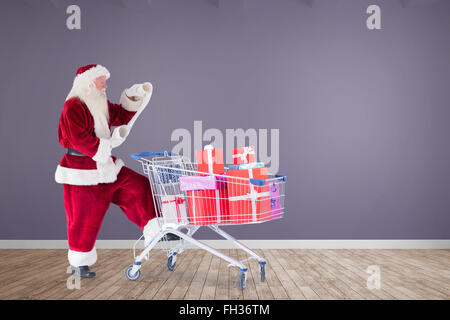 Composite image of santa delivering gifts from cart Stock Photo