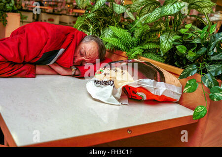 Fatigue sleeping old man in a shopping center Loneliness Stock Photo