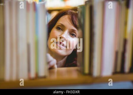 Mature student picking out book in library Stock Photo