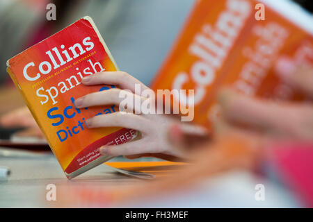 A Spanish language lesson in a school and hands holding well worn spanish dictionaries. Stock Photo