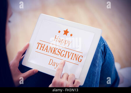 Composite image of teen using a tablet pc sitting on the floor Stock Photo