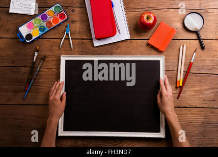 Hands of man with empty picture. Various school supplies. Stock Photo