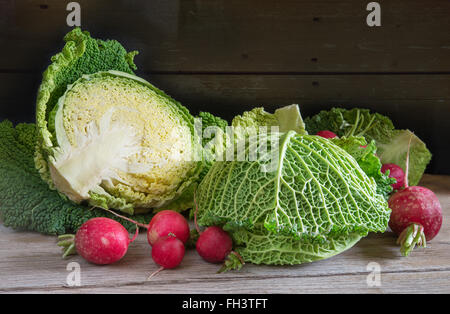 fresh savoy cabbage and radish on wood Stock Photo