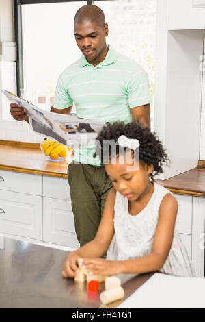 Concentrated father reading newspaper Stock Photo