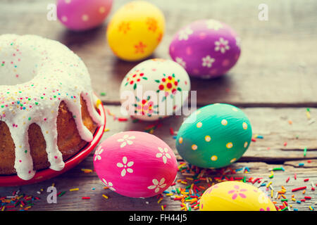 Easter cake and colorful eggs on kitchen table. Retro styled. Stock Photo