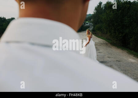 bride leads groom on the road Stock Photo