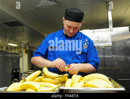 PACIFIC OCEAN (Feb. 22, 2016) Culinary Specialist 3rd Class Ryan Wheaton inspects bananas in the bake shop aboard amphibious assault ship USS Boxer (LHD4). More than 4,500 Sailors and Marines from Boxer Amphibious Ready Group and the 13th Marine Expeditionary Unit (13th MEU) are conducting sustainment training off the coast of Hawaii in preparation for entering the U.S. 5th and 7th Fleet areas of operations Stock Photo