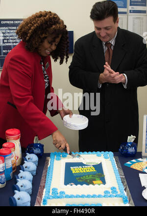 NAVAL AIR FACILITY ATSUGI, Japan (Feb. 22, 2016) – Navy Federal Credit Union Atsugi branch manager Brenda Williams, left, and Fleet and Family Support Center financial adviser Brad Morgan prepare to serve cake to those in attendance of the Military Saves Week kickoff held at Naval Air Facility Atsugi’s Navy Federal Credit Union. Military Saves is a component of the nonprofit America Saves and a partner in the Department of Defense's Financial Readiness Campaign that seeks to motivate, support, and encourage military families to save money, reduce debt, and build wealth. Stock Photo