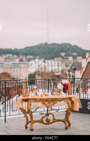 Luxurious golden wedding table on the terrace with amazing view of ancient Lviv city Stock Photo