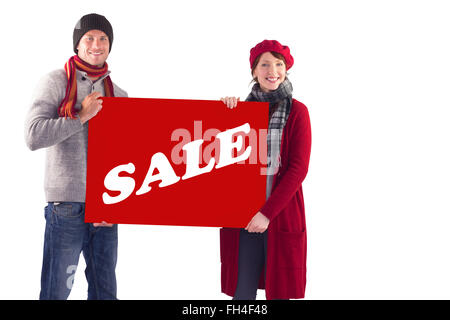 Composite image of couple holding a large sign Stock Photo
