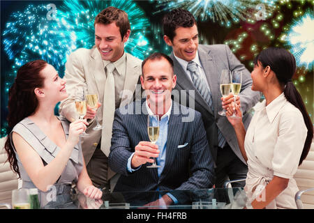 Composite image of smiling business team celebrating a success with champagne Stock Photo