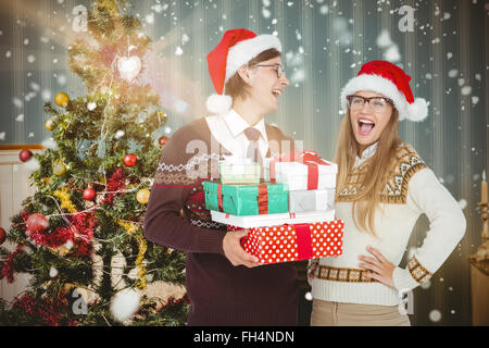 Composite image of geeky hipster couple holding presents Stock Photo